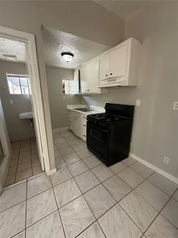 a kitchen with stainless steel appliances a sink a stove a refrigerator and cabinets