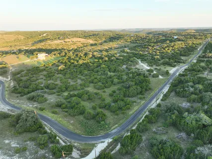 an aerial view of residential houses with outdoor space and trees