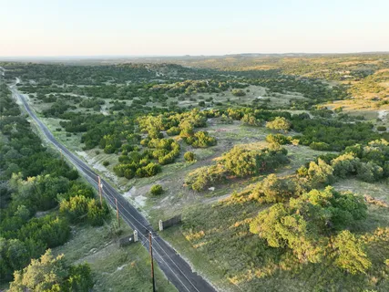 an aerial view of residential houses with outdoor space and trees
