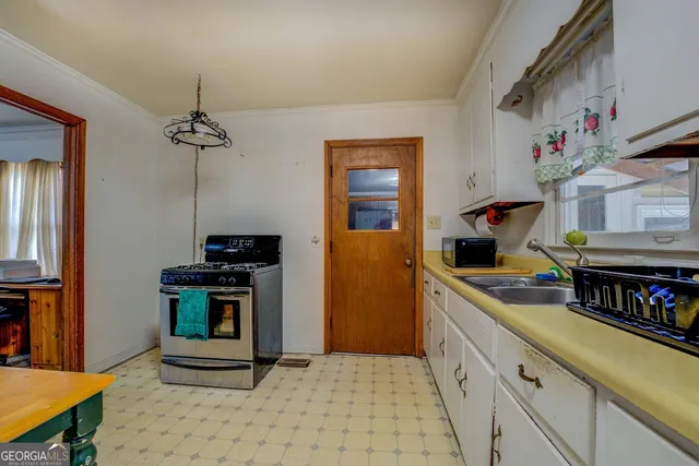 a kitchen with granite countertop a stove and a sink