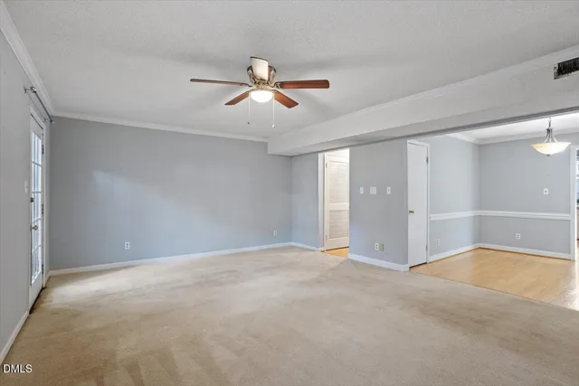 a view of an empty room with window and a ceiling fan