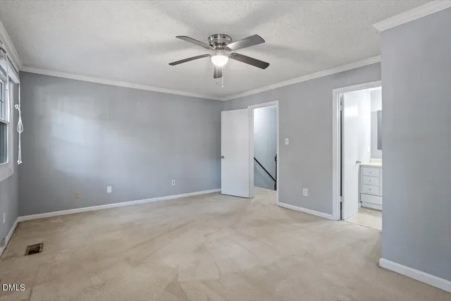 an empty room with closet and ceiling fan