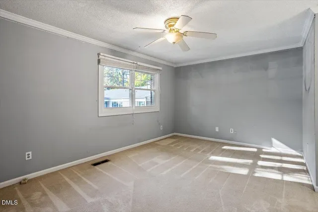 an empty room with a window and a ceiling fan
