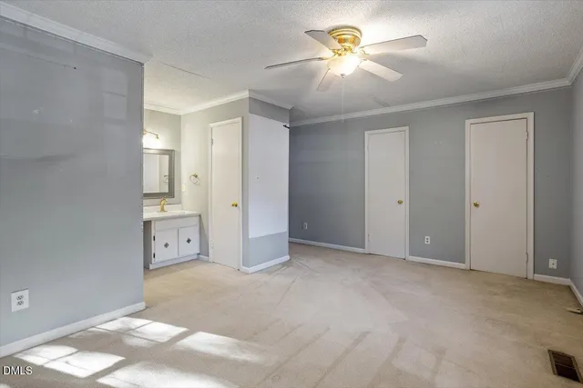 an empty room with closet and a chandelier fan