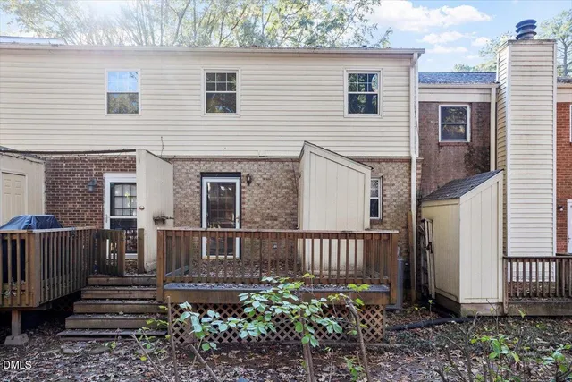 a view of a house with wooden floor next to a yard