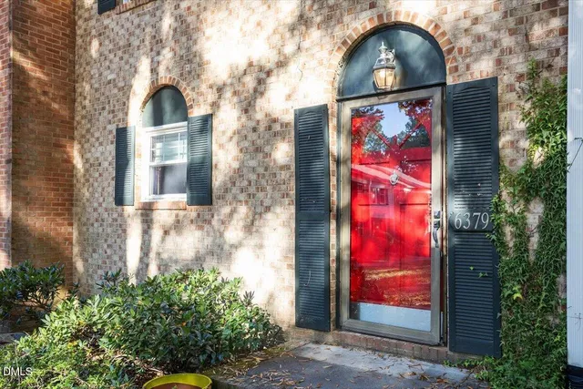 a view of a brick house with a large windows and a potted plant