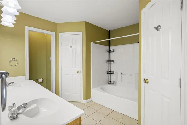 a bathroom with a tub sink and shower