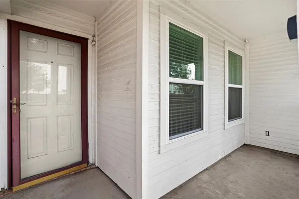 a view of a porch with a door and a yard
