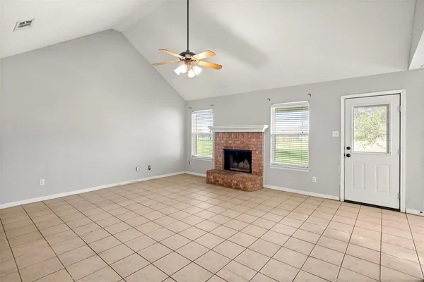 an empty room with windows and fireplace