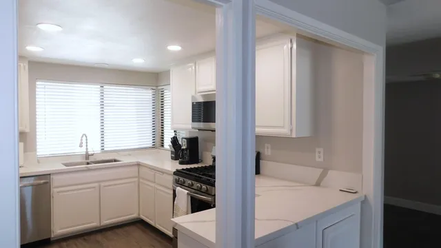 a kitchen with a sink stove top oven and cabinets