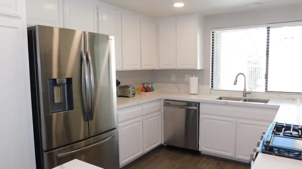 a kitchen with stainless steel appliances a refrigerator sink and cabinets