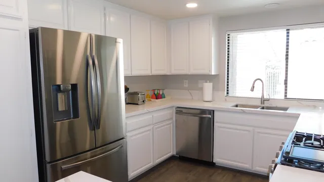 a kitchen with stainless steel appliances a refrigerator sink and cabinets