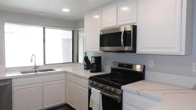 a kitchen with stainless steel appliances granite countertop a sink stove and microwave