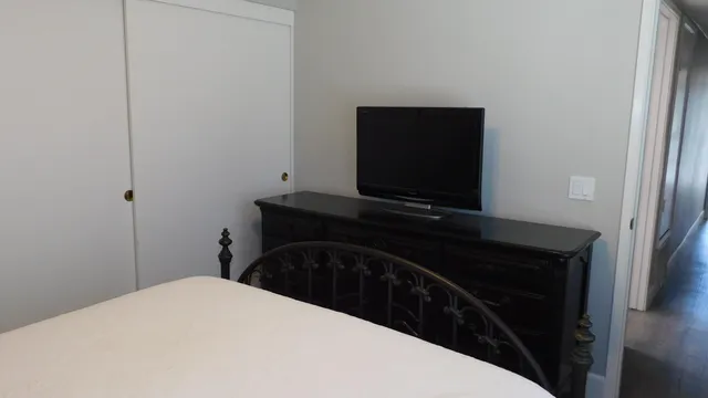 a bedroom with a bed and a flat screen tv