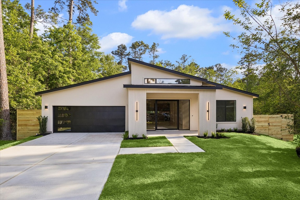 10943 Mockingbird Place Conroe, TX 77385 - Photo 1 of 24 a front view of a house with a yard and garage