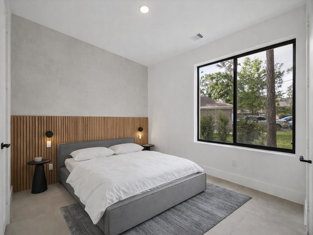 10943 Mockingbird Place Conroe, TX 77385 - Photo 14 of 24 a bedroom with a bed and a large window