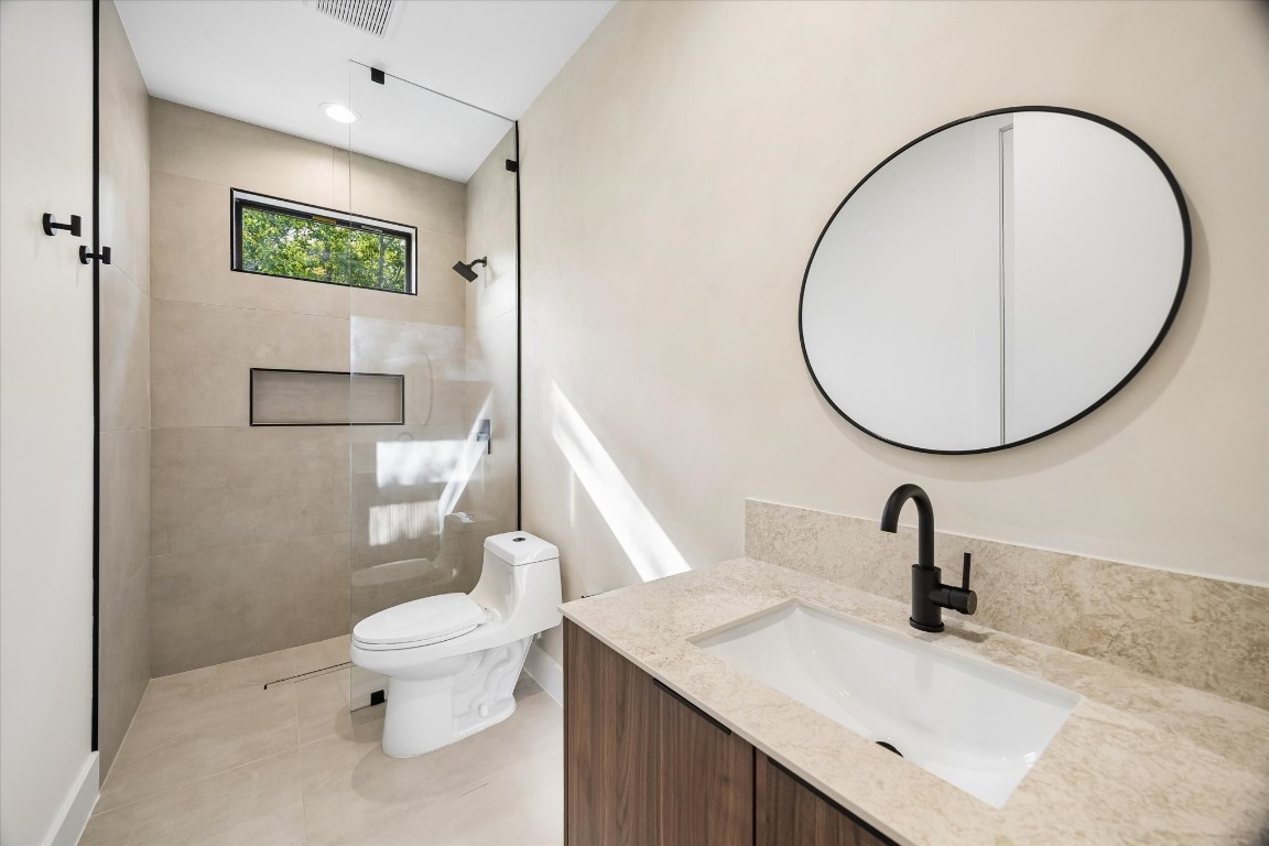 10943 Mockingbird Place Conroe, TX 77385 - Photo 18 of 24 a bathroom with a sink a toilet and a mirror