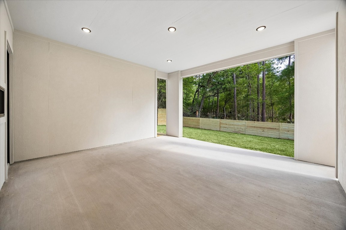 10943 Mockingbird Place Conroe, TX 77385 - Photo 19 of 24 a view of a room with large windows and a small yard
