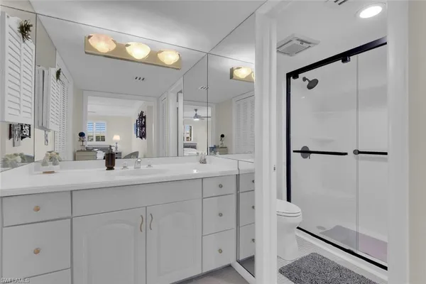 a bathroom with a double vanity sink mirror and shower