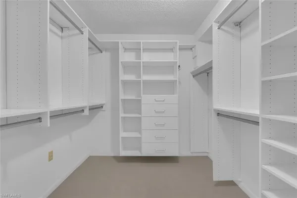 a view of walk in closet with empty racks