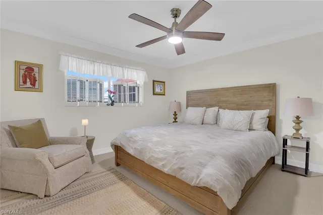 a bedroom with a large bed couch and a ceiling fan