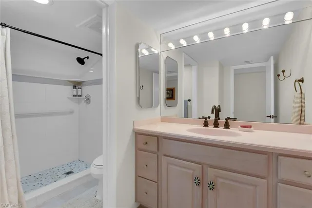 a bathroom with a double vanity sink mirror and shower