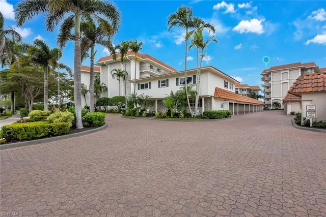 a front view of a house with a yard and potted plants