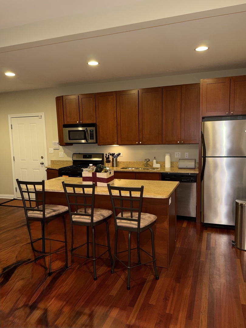 4546 North Spaulding Avenue, Unit 1 Chicago, IL 60625 - Photo 6 of 22 a kitchen with a table chairs refrigerator and a microwave