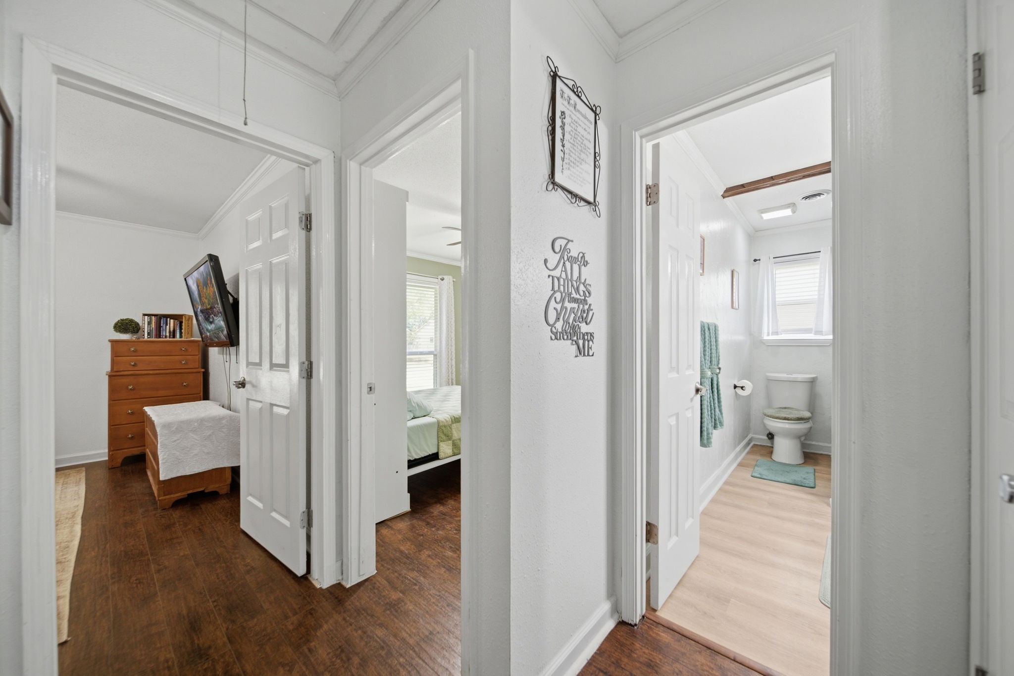 19519 Ricelake Lane Houston, TX 77084 - Photo 24 of 47 Bright and welcoming hallway with rich wood flooring, leading to a cozy bedroom and a well-lit bathroom, offering a functional and inviting layout.