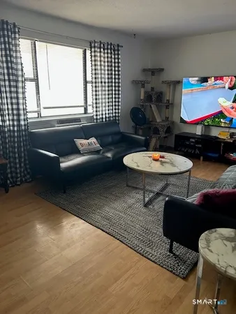 a living room with furniture a flat screen tv and a large window