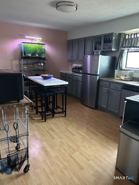 56 Angel Drive, Unit C Waterbury, CT 06708 - Photo 4 of 10 a kitchen with stainless steel appliances kitchen island granite countertop a table chairs and a refrigerator
