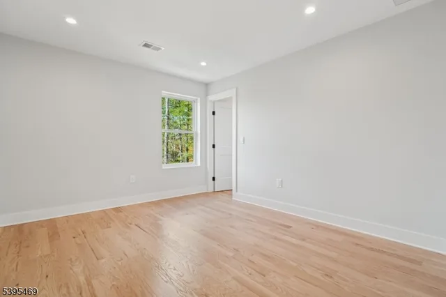 an empty room with wooden floor and window