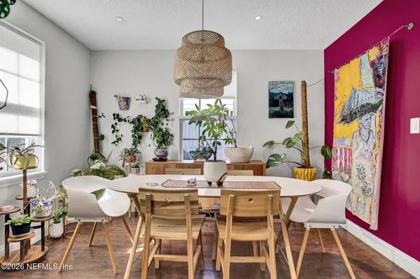 a dining room with furniture a large window and wooden floor