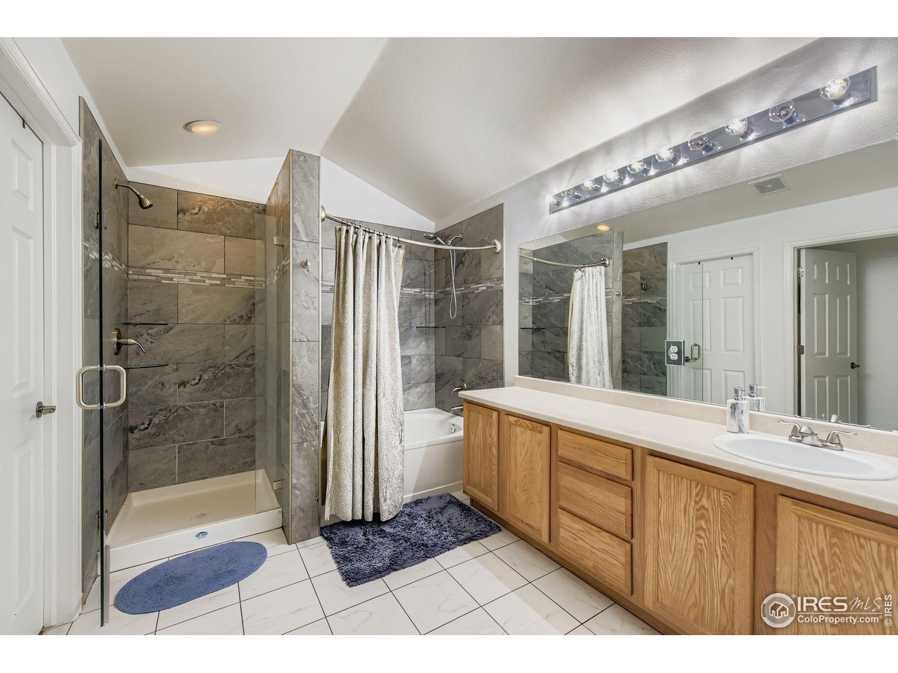8320 Stonybridge Circle Highlands Ranch, CO 80126 - Photo 7 of 9 a bathroom with a double vanity sink a large mirror and shower