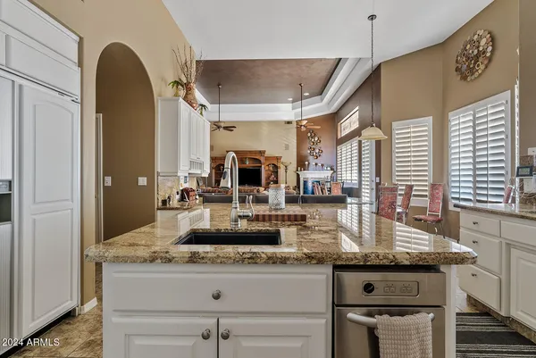 a kitchen with granite countertop a table chairs stove and cabinets