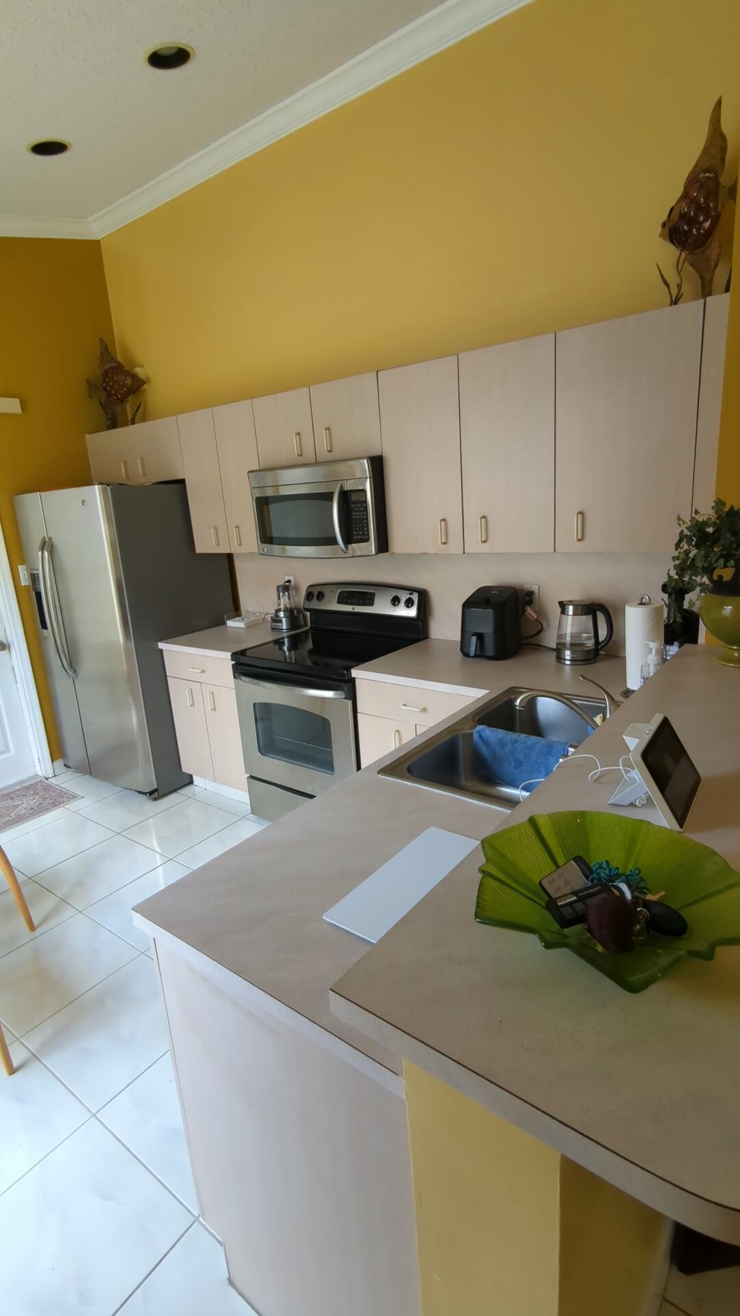 1481 Southwest 105th Avenue Pembroke Pines, FL 33025 - Photo 4 of 9 a kitchen with a sink a stove and cabinets