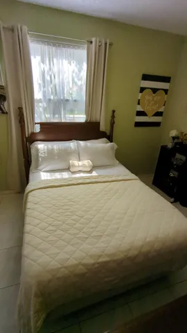 a bed sitting in a bedroom next to a window