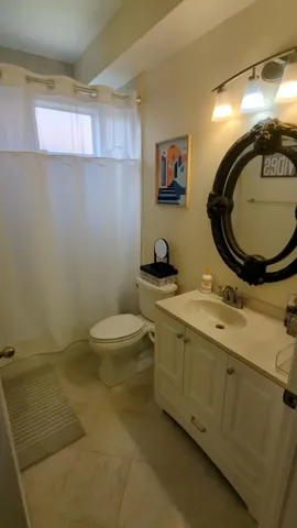 a bathroom with a granite countertop toilet sink and mirror