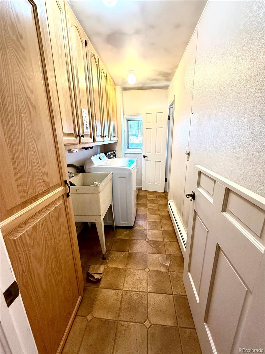 6105 West 49th Place Wheat Ridge, CO 80033 - Photo 32 of 40 a bathroom with a sink a toilet and a mirror