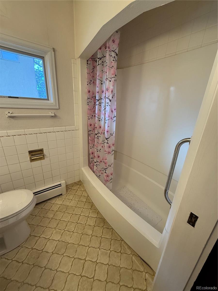 6105 West 49th Place Wheat Ridge, CO 80033 - Photo 33 of 40 a bathroom with a toilet and a shower