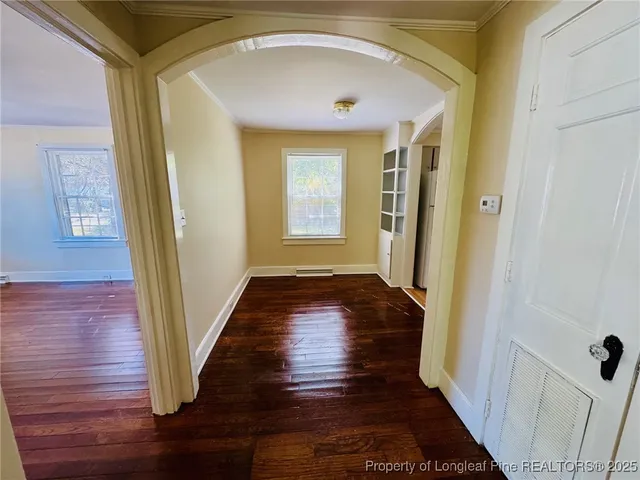 a view of a hallway with wooden floor and staircase