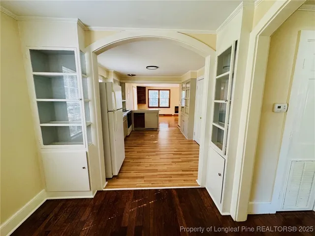 a view of a hallway with wooden floor and staircase