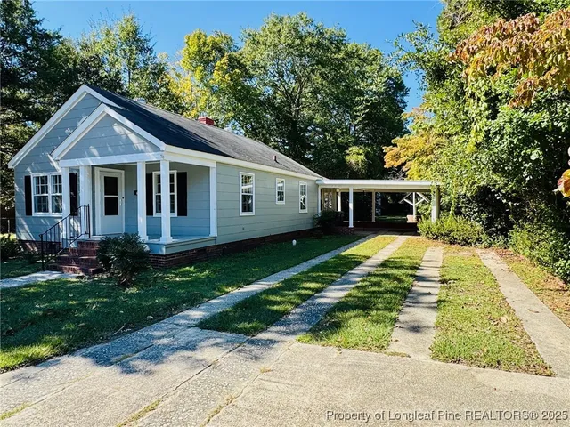 a view of a patio with table and chairs potted plants and large tree