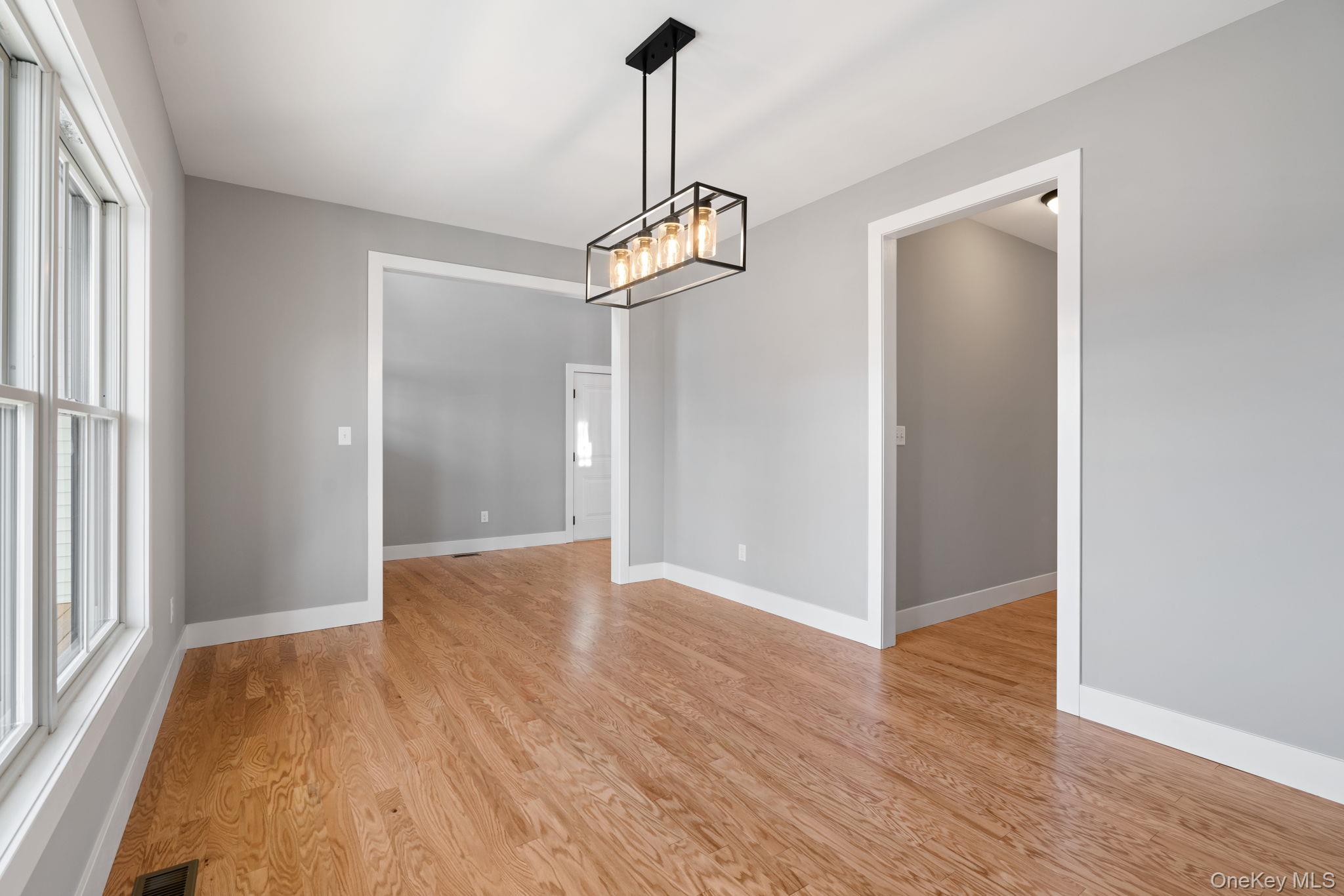13 Harrier Ridge Drive Wallkill, NY 12589 - Photo 13 of 40 Unfurnished dining area with light wood-style flooring and a chandelier