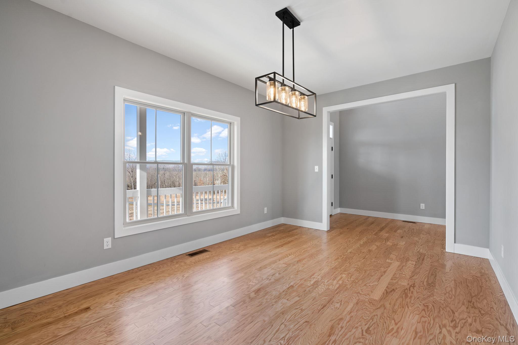 13 Harrier Ridge Drive Wallkill, NY 12589 - Photo 14 of 40 Spare room featuring light wood-style flooring and a chandelier