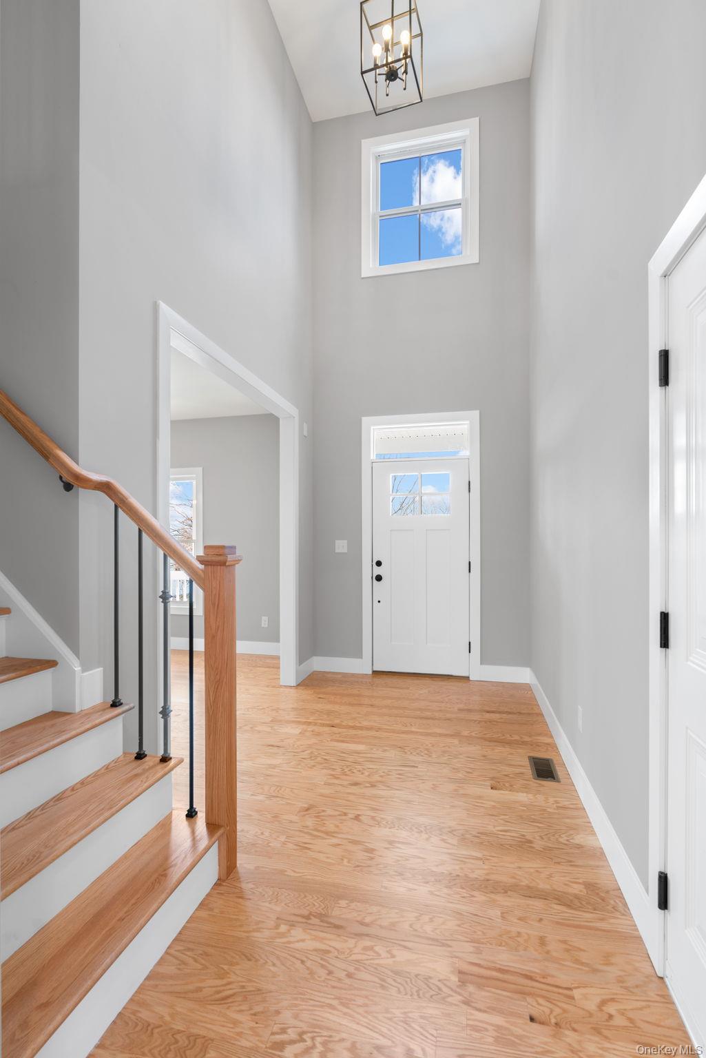 13 Harrier Ridge Drive Wallkill, NY 12589 - Photo 15 of 40 Entryway with a high ceiling, light wood-style flooring, stairs, and a chandelier