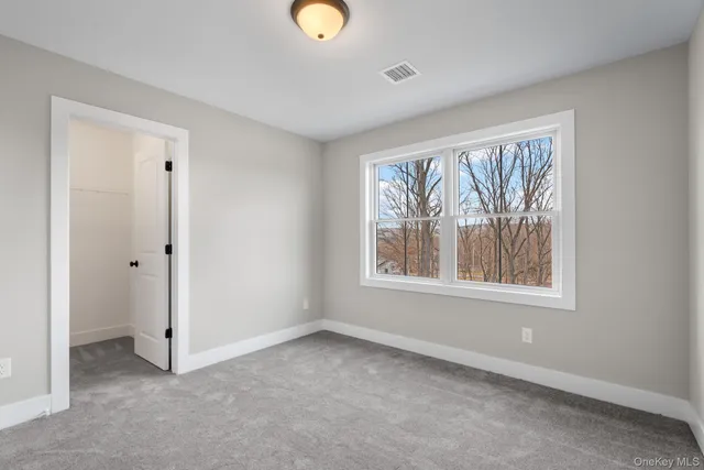 an empty room with windows and closet