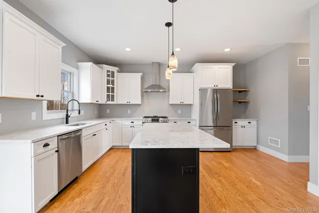 a large kitchen with stainless steel appliances kitchen island a sink refrigerator and cabinets