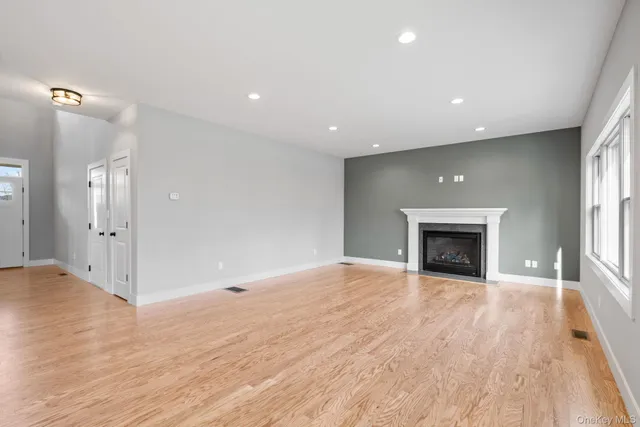 a view of empty room with wooden floor and fireplace