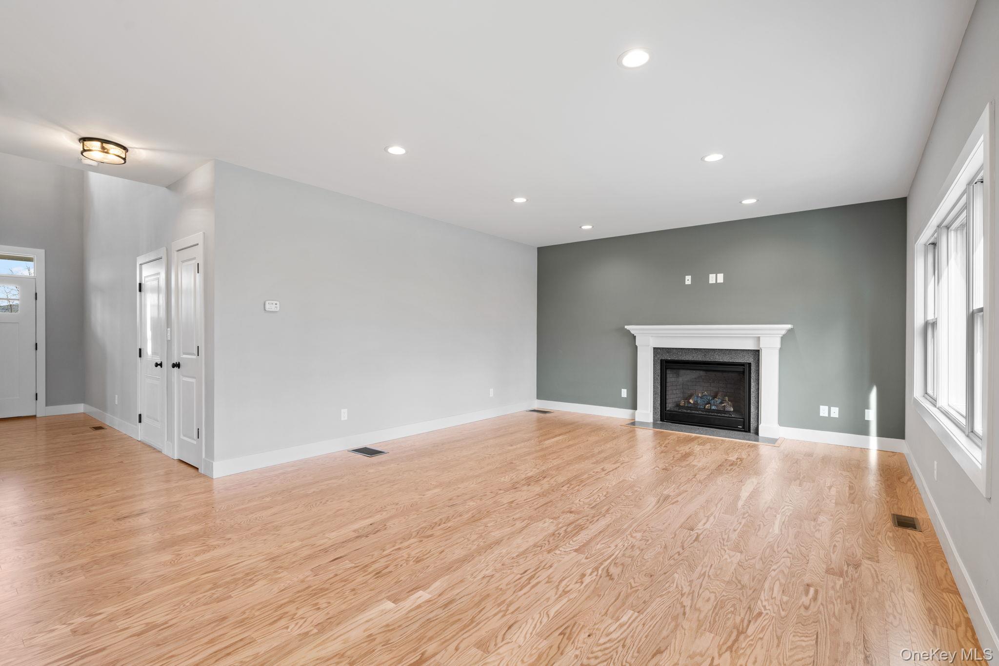 13 Harrier Ridge Drive Wallkill, NY 12589 - Photo 8 of 40 Unfurnished living room featuring healthy amount of natural light, recessed lighting, light wood finished floors, and a fireplace with flush hearth